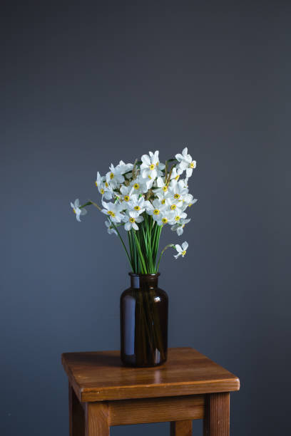 istock White daffodils in a brown glass jar 684355980