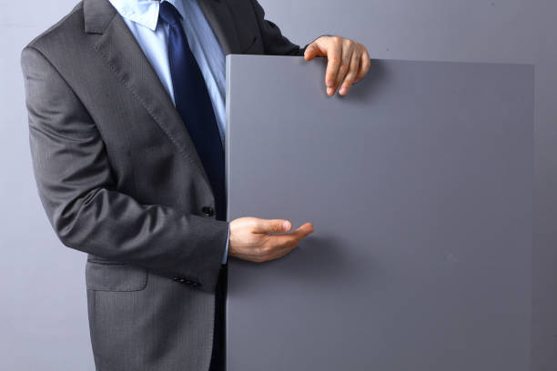 istock Businessman holding a blank board, pointing something 684359616