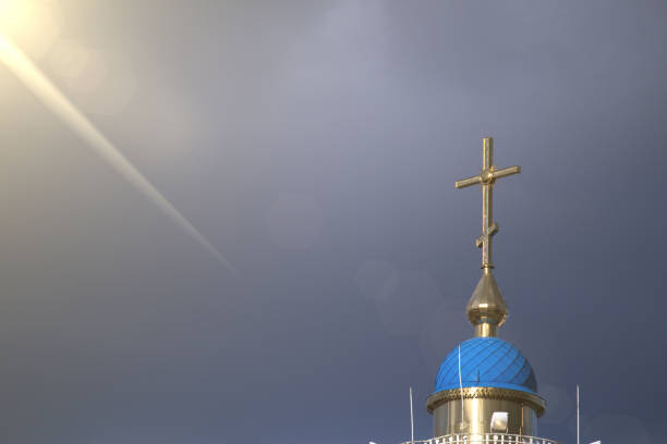 istock A large Christian cross on which falls a ray of sun through the clouds 684364970