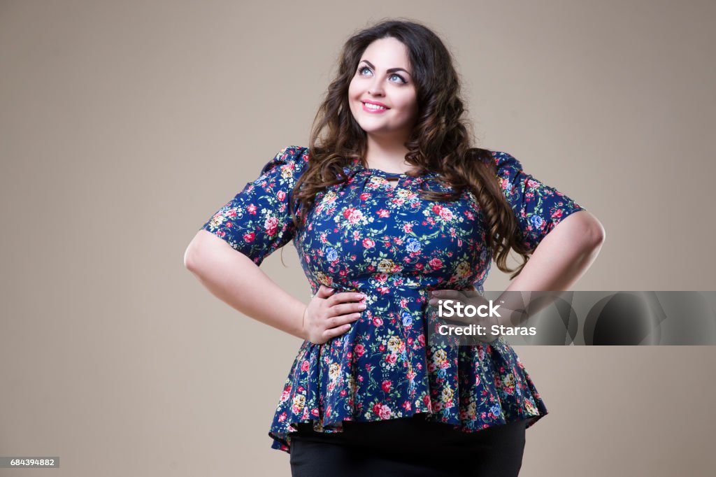 Plus size fashion model in casual clothes, fat woman on beige studio background, overweight female body Plus size fashion model in casual clothes, fat woman on beige studio background, overweight female body, professional make-up and hairstyle Women Stock Photo