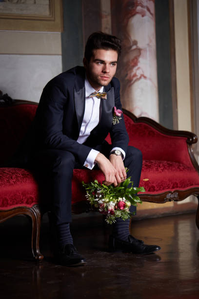 istock young groom waiting his bride on sofa 684451740
