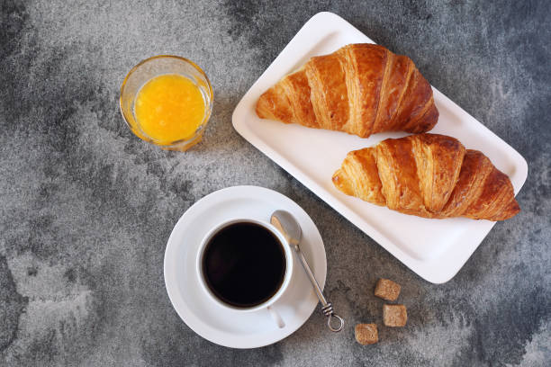 istock Two croissants, orange juice and coffee 684454484