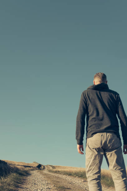 istock Man stood looking out over  a long dirt road. 684470982