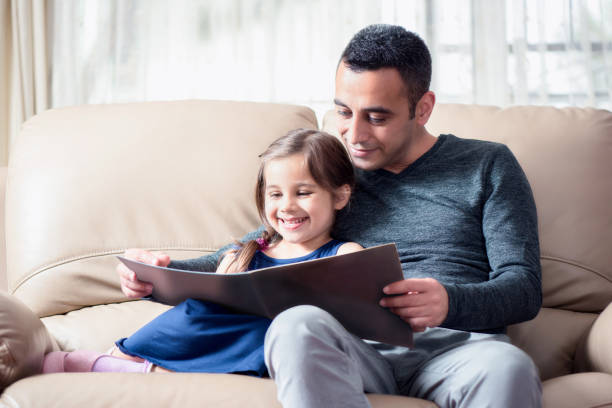 istock Little Girl And Father Reading Book 684474984