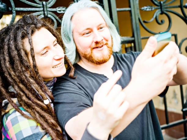 istock Young freaky couple messaging on the street 684523100
