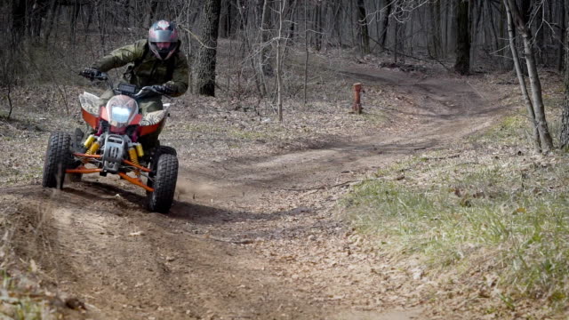 Extreme vacation in the woods on the ATV. Men engage in motor sport, quad bike is an ideal means for riding on country roads. All wheel drive helps to overcome obstacles, and to conquer the terrain
