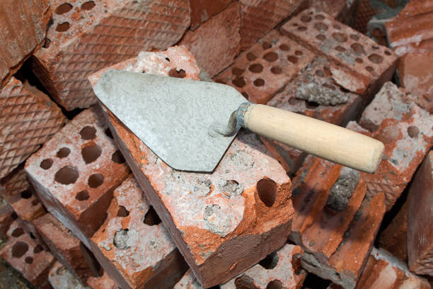 istock An old building tool, a trowel lying on a pile of red bricks. 684558600