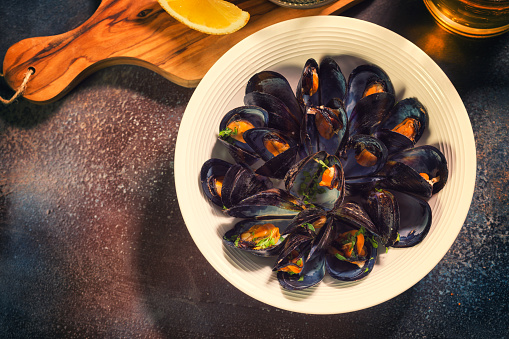 Freshly steamed blue mussels dish with french fries,chili pepper and parsley