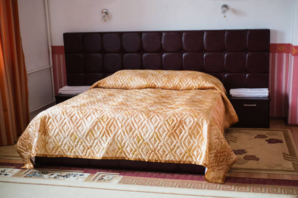 istock A large bed in the bedroom with a beige blanket. Daylight. 684589702