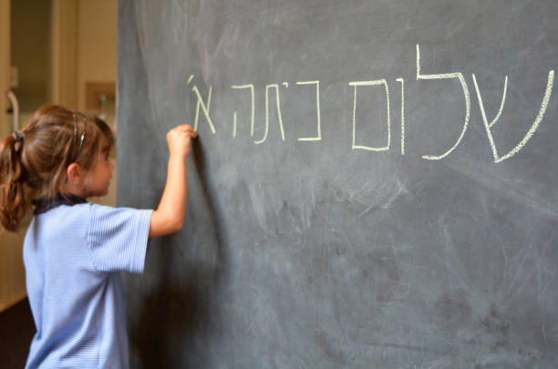 la petite fille écrit bonjour salutations de première année en hébreu - alphabet blackboard text child photos et images de collection