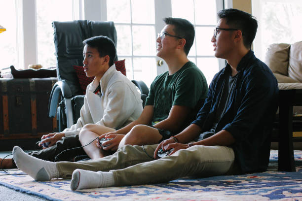 アジア系アメリカ人 10 代のビデオ ゲームをプレイ - asianamerican ストックフォトと画像