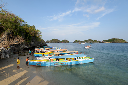 Quezon Island, Philippines - April 11, 2017: Tourist boats waiting for customers at the Quezon Island in the Hundred Islands National Park in the Philippines.