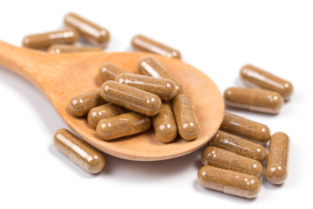 istock Turmeric capsules in wooden spoon on white 684648198