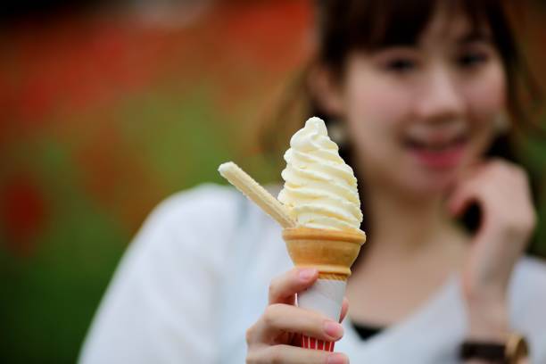istock Young woman eating ice cream at park 684648636