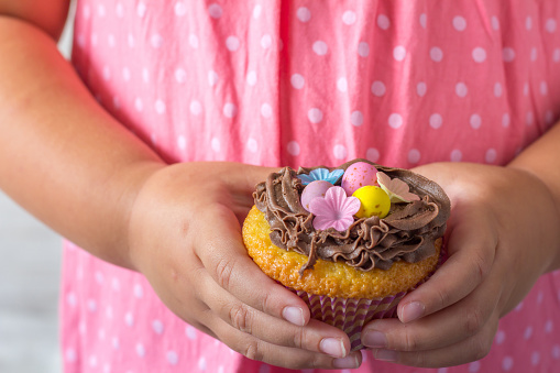 Close Up of Little Girl Holding an Easter Cupcake in her Hands Selective Focus