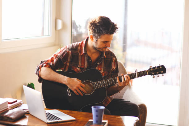 young man playing a guitar - men artist guitarist guitar imagens e fotografias de stock