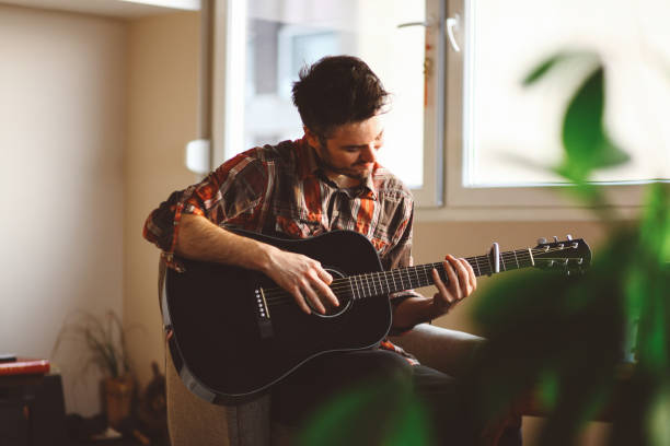 młody człowiek gra na gitarze - acoustic guitar guitarist country and western music guitar zdjęcia i obrazy z banku zdjęć