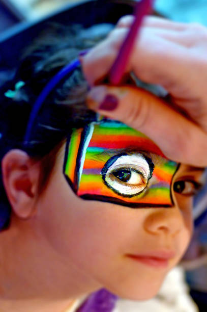 istock Young girl getting her face painted in rainbow colors 684683094