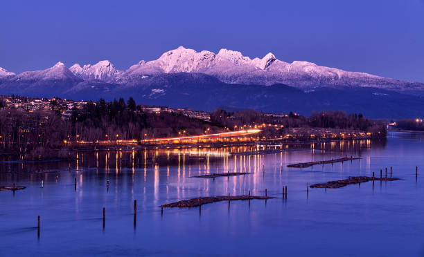 Fraser river at dusk in winter, British Columbia, Canada Fraser river and snow-capped mountain in winter, long exposure. surrey british columbia stock pictures, royalty-free photos & images