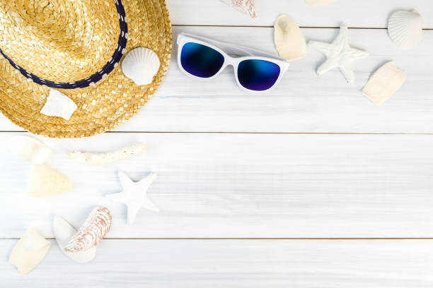 istock Summer Beach accessories (White sunglasses,starfish,straw hat,shell) on white plaster wood table top view,Summer vacation concept,Leave space for adding text 684703712