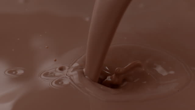 Chocolate milk pouring and splashing in slow motion