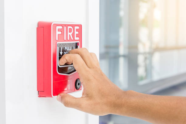 istock Hand of man pulling fire alarm switch on the white wall as background for emergency case at the new factory building. 684707094