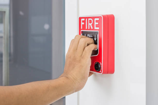 istock Hand of man pulling fire alarm switch on the white wall as background for emergency case at the new factory building. 684707096