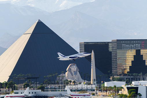 Las Vegas, USA - March 12,2017: Telephoto shot of Buildings of Las Vegas Hotel & Casino. Passenger jet airplane taking off from Mccarran International Airport  in the foreground .Las Vegas is world famous for night entertainment show and convention center.