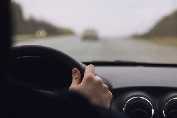 istock Man's hands on a wheel - inside a car at highway 684726030