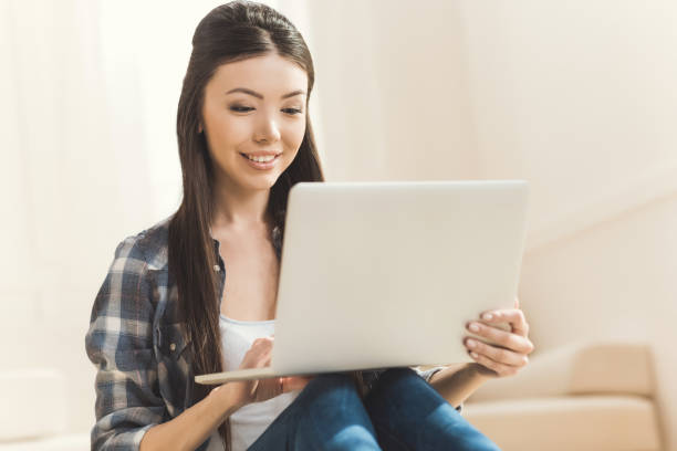 istock woman sitting on floor and working on laptop 684754546