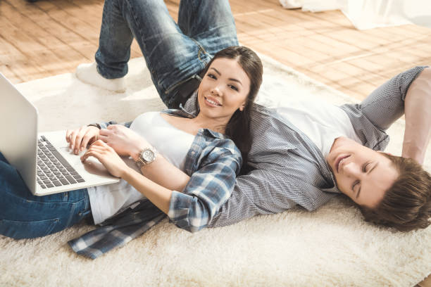 istock woman lying on boyfriend and using laptop 684754628