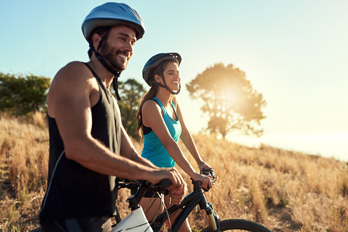Shot of a happy young couple out mountain biking together