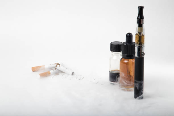 istock Broken tobacco cigarettes with modern electronic cigarette and e-juice bottles with smoke 684757934