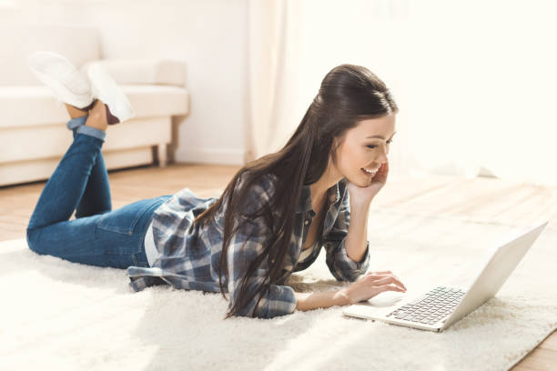 istock woman lying on carpet and using laptop 684761010