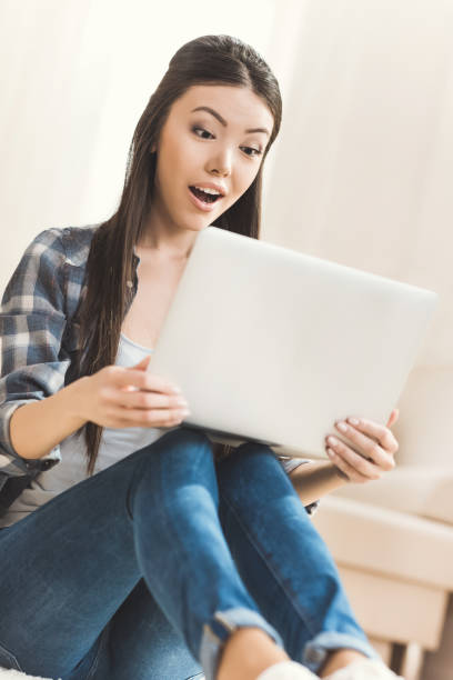 istock woman sitting on floor and working on laptop 684761096