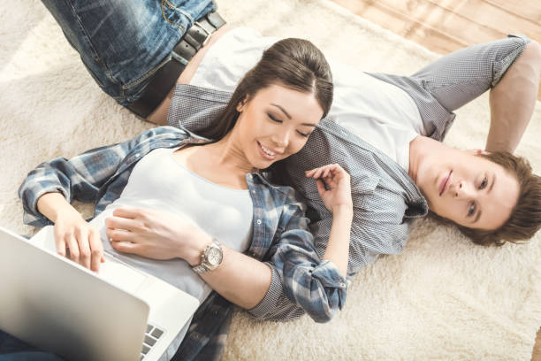 istock woman lying on boyfriend and using laptop 684761158