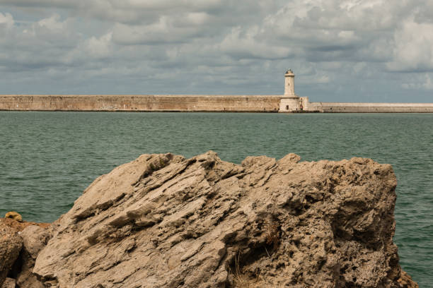 istock Tuscany Coastline: White Lighthouse Tower, Cliffs and Stone Jetty near Sea, Italy 684764520