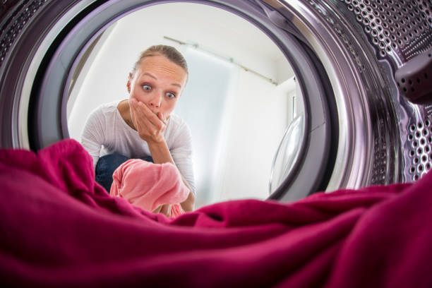 istock Young woman doing laundry - view from the washing machine 684765154