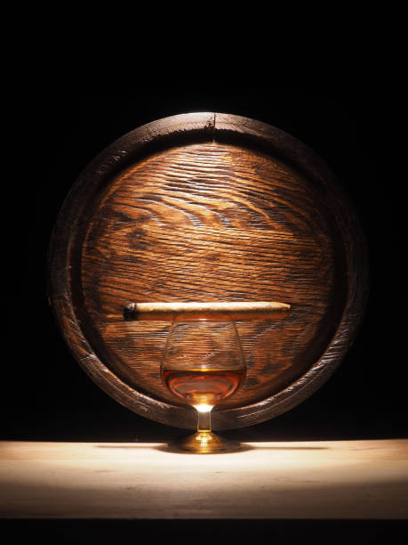 istock Glass of brandy, Cigar and old oak barrel 684793640