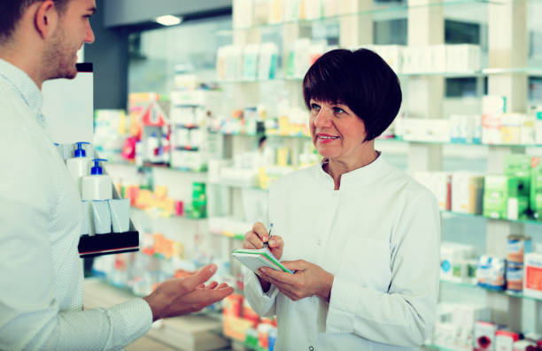 istock Woman druggist wearing white coat 684799554