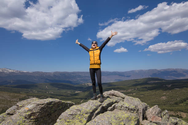 woman screaming on top of mountain stock photo