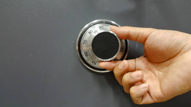 istock Close up of a safe lock and male hand conceptual image 684800616