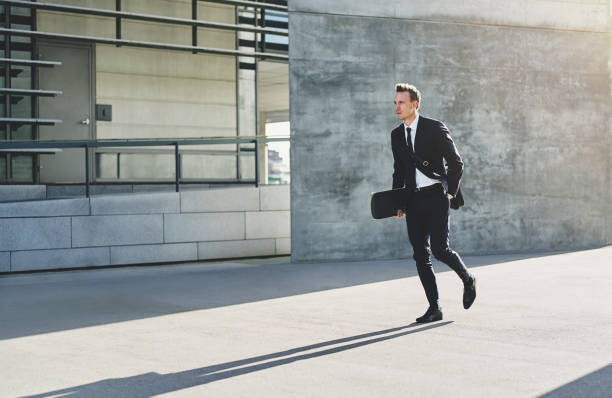 istock Young businessman with skateboard walking in rush 684804372