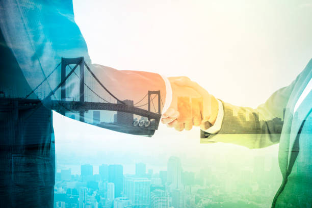 istock Double exposure of two business persons shaking hands and bridge skyline, relationship conceptual abstract 684807642