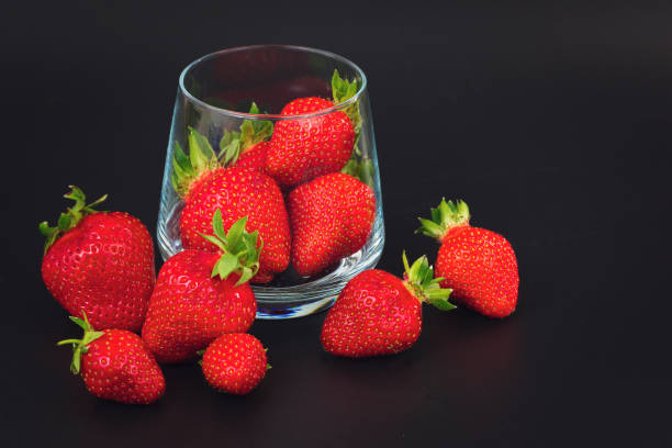 istock Organic fresh strawberries fruit in glass on black background 684810486