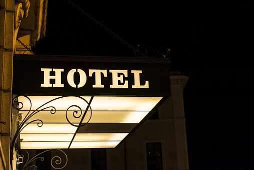 Hotel sign illuminated at night in a classic building in Rome, Italy