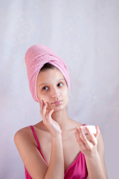 istock Girl with a pink towel holding a cream 684830234