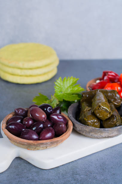 средиземноморская закуска antipasti тапас миски с зелеными и каламата оливки, сыр фета, фаршированный перец с чесночным лаваш, травы на белой мр - calamata olive стоковые фото и изображения