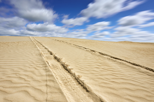 Car tyre track in the desert in blue sky, Western Australia.