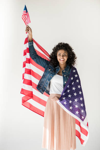 istock woman standing with american flag 684846502
